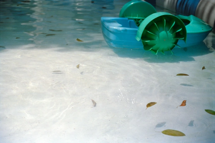 Turquoise paddle boat floats on clear water
